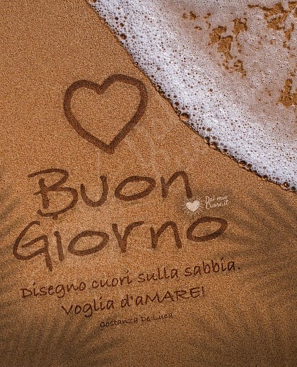 Bagnasciuga con due cuori tracciati sulla sabbia bagnata dall'onda del mare e la scritta Voglia d'aMARE! Buon Giorno a te.